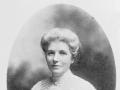 Head and shoulders portrait of unsmiling woman in formal dress