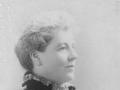 Profile portrait of unsmiling woman in formal dress