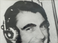 Pilot in cockpit of aircraft with ear phones on smiling at the camera