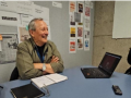 Smiling middle-aged man sitting at table with laptop open 