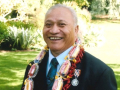 Smiling man in suit with lei around his neck