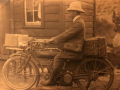 Cromwell Shepherd sitting on a motorbike outside of a house.