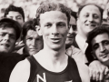 Jack Lovelock wearing a New Zealand running singlet in a crowd