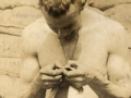 New Zealand soldier checking his shirt for lice, May 1917