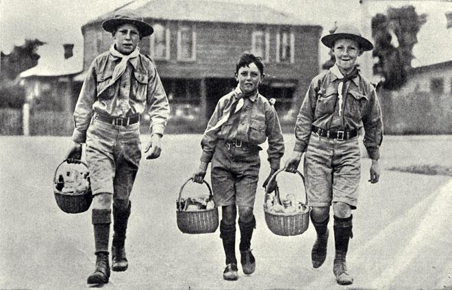 Three boys in uniform carrying baskets