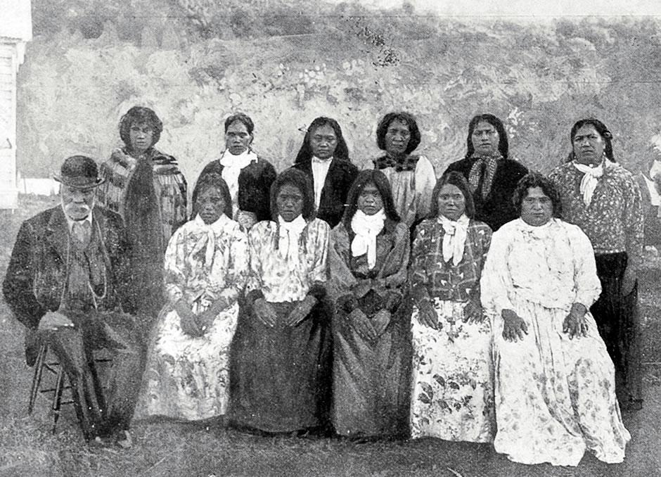 Group of Māori women and one man sitting and standing in two rows