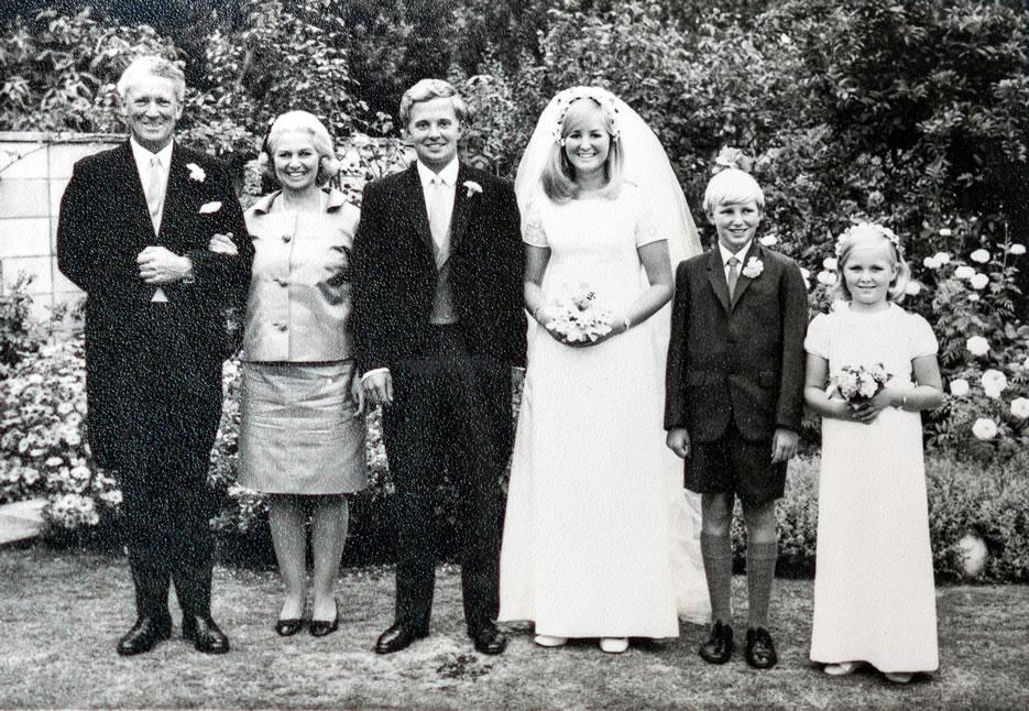Family wedding photo with parents on left, groom and bride in middle and boy and girl on the right