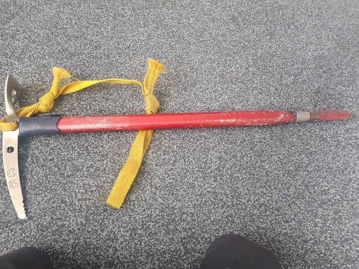 Red metal pick axe with writing on it