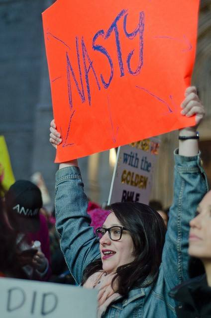 Women holding up 'Nasty' sign