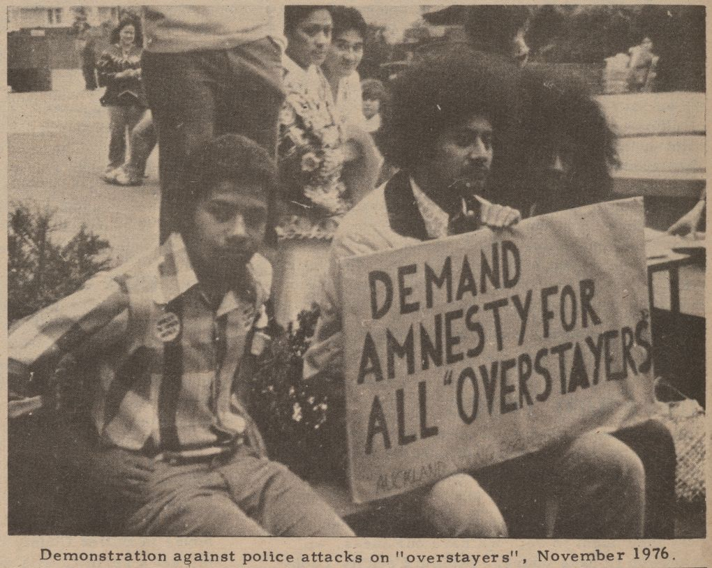 Seated protestors with sign proclaiming 'Demand Amnesty for All "Overstayers"' from November 1976