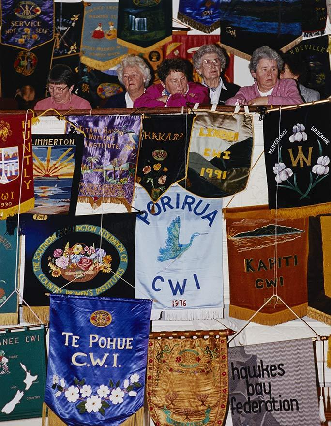 Women gathered in theatre with banners over balcony